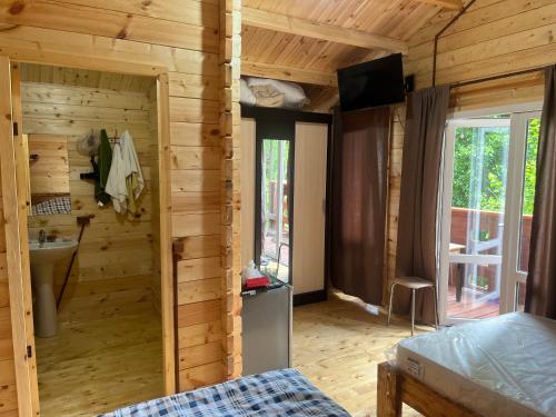 a bedroom in a log cabin with a bed and a television at Cypress House in Novy Afon
