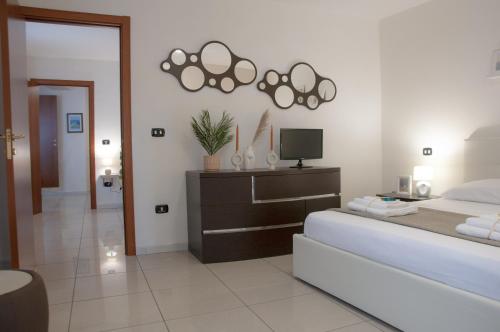 een slaapkamer met een bed, een dressoir en een tv bij Le Muse in Caserta