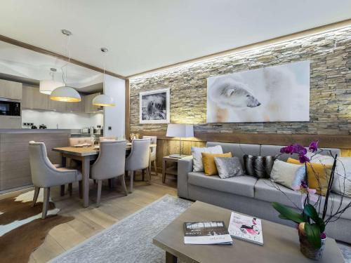 un salon avec un canapé et une table dans l'établissement Appartement Neuf Centre Courchevel Village, Proche Commerces et Pistes, Parking et Fitness Inclus - FR-1-562-33, à Courchevel
