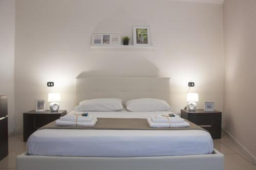 een slaapkamer met een groot bed met 2 nachtkastjes bij Le Muse in Caserta