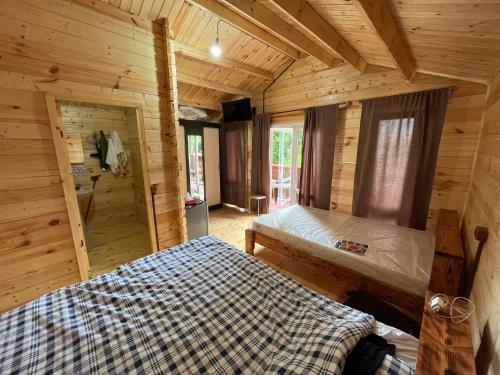 a bedroom in a log cabin with a bed at Cypress House in Novy Afon