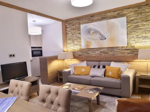 un salon avec un canapé et une télévision dans l'établissement Appartement Raffiné aux Pieds des Pistes avec Parking et Accès Fitness - FR-1-562-52, à Courchevel