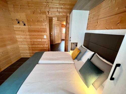 ein Schlafzimmer mit einem großen Bett in einem Holzzimmer in der Unterkunft Ferienhaus Nordland in Bachenbrock