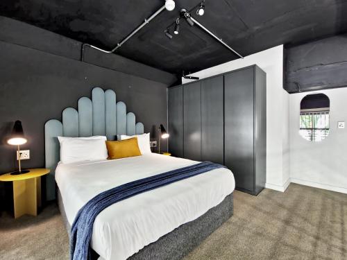 a bedroom with a large bed with a blue headboard at BlackBrick Cape Town Foreshore in Cape Town