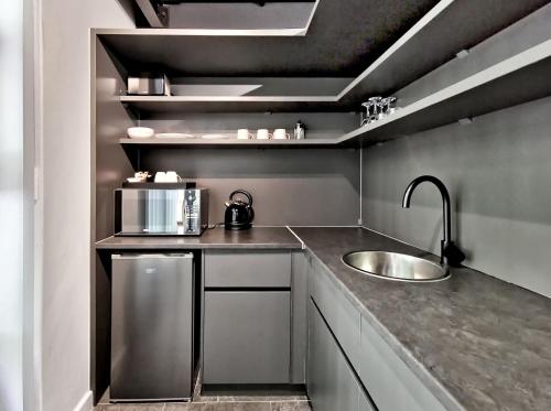 a small kitchen with a sink and a microwave at BlackBrick Cape Town Foreshore in Cape Town