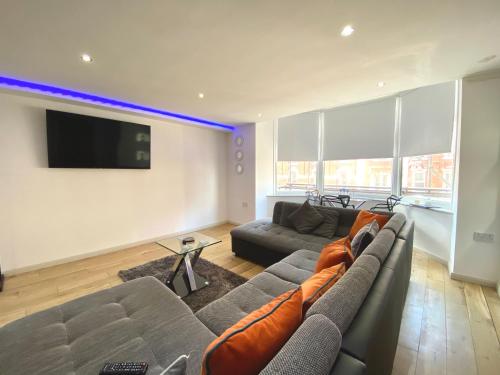 a living room with a couch and a flat screen tv at Princess Theatre Beach View Apartments by Blackpool Service Apartments in Blackpool