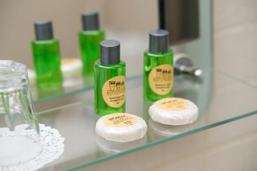 three green bottles of moisturizers sitting on a bathroom counter at Bogolvar Retreat Resort in Antonovka