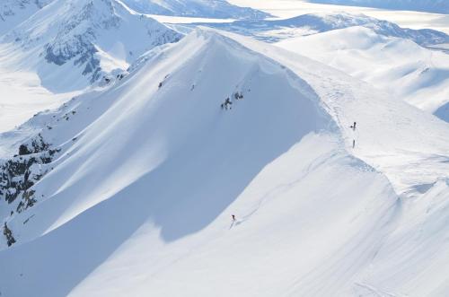 a group of people skiing down a snow covered mountain at Viking Cabins - MIT FabLab - Solvik in Kvalvik