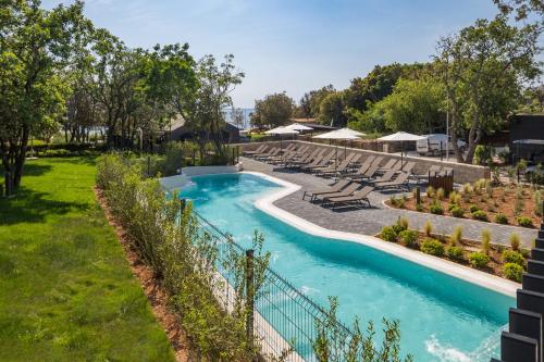 a swimming pool with lounge chairs and a resort at Luxury Glamping Beach Villas Porto Bus in Bale