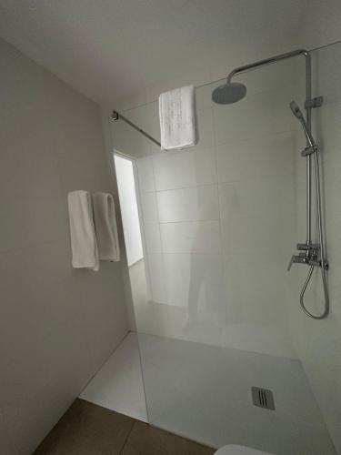 y baño blanco con ducha y aseo. en RAQUEL'S - Habitacions i Apartaments turístics - en Sant Pere Pescador