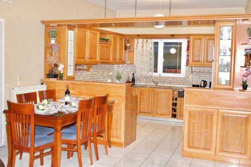 una cucina con tavolo e sedie in legno e una cucina con bancone di George Airport Apartments a Heraklion