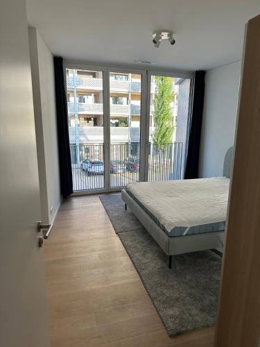 a bedroom with a bed and a large window at Wohnung im Trendquartier zentral - 24-7 check-in with keybox in Zurich