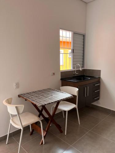 uma cozinha com uma mesa e cadeiras e um lavatório em Residencial Maurice et Madeleine em São Paulo