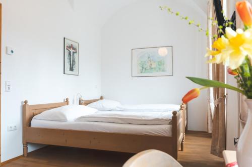 a bedroom with a bed and a vase with flowers at Seminarzentrum Stift Schlägl in SchlÃ¤gl