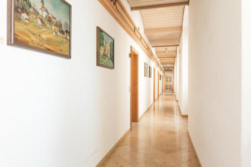 a corridor in a building with paintings on the walls at Seminarzentrum Stift Schlägl in SchlÃ¤gl