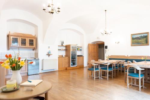 una cucina e una sala da pranzo con tavoli e sedie di Seminarzentrum Stift Schlägl a SchlÃ¤gl