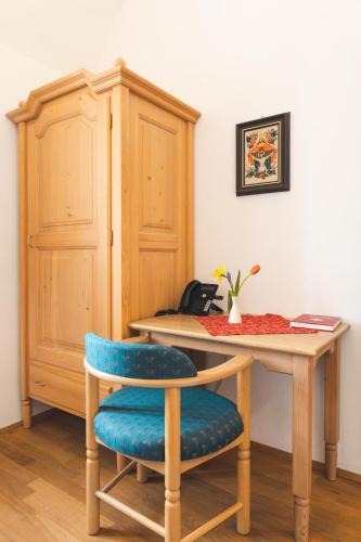 a wooden table with a blue chair and a desk at Seminarzentrum Stift Schlägl in SchlÃ¤gl