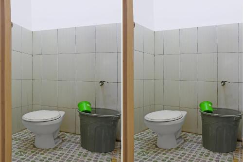 - une salle de bains avec 2 toilettes et 2 poubelles vertes dans l'établissement OYO 92593 Penginapan Sultan Haji 1, à Bandar Lampung