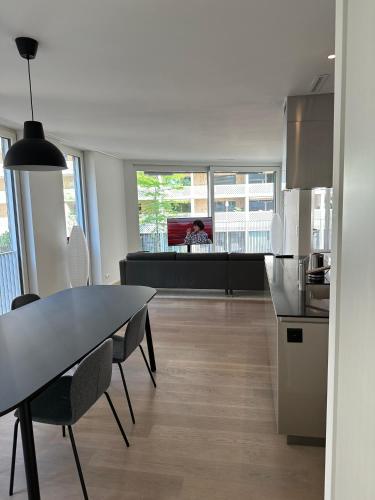 チューリッヒにあるWohnung im Trendquartier zentral - 24-7 check-in with keyboxのテーブルと椅子のあるキッチンとリビングルーム