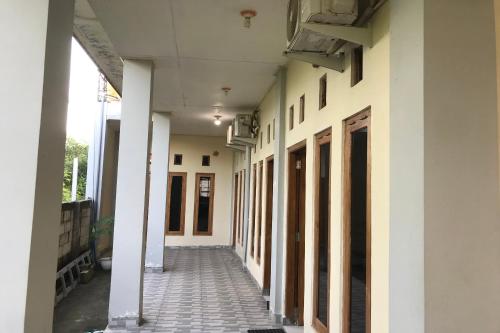 an empty hallway of a building with white walls at Hotel O Penginapan Mc Lodge in Labuan Bajo