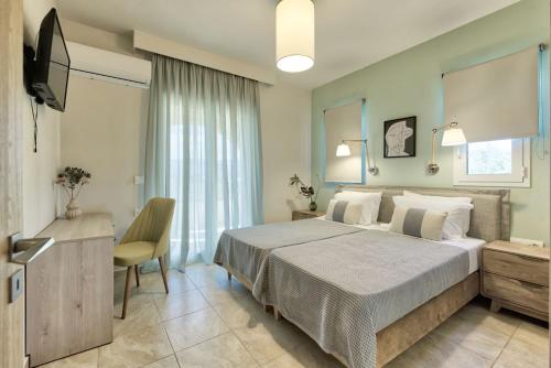 una camera con un grande letto e una televisione di Diogia Luxury Apartment a Vanáton