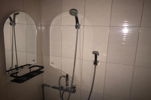 y baño con ducha y espejo. en OYO 92608 Penginapan Mc Lodge en Labuan Bajo