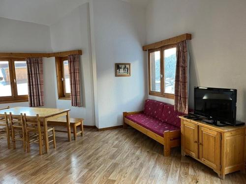 a living room with a red couch and a table at La Tania La Saboia sleep 8 private Sauna lounge dining 2 bathrooms kitchen 2 balconies ski in out in La Tania