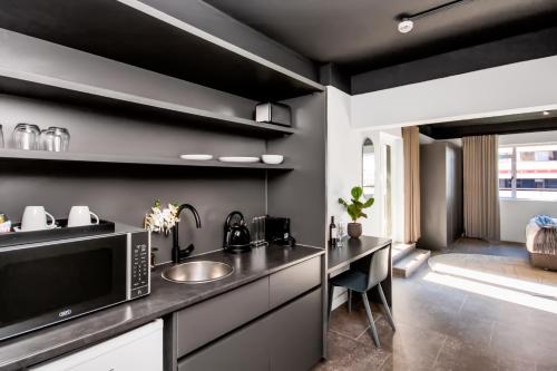 a kitchen with a sink and a microwave at BlackBrick Cape Town Foreshore in Cape Town