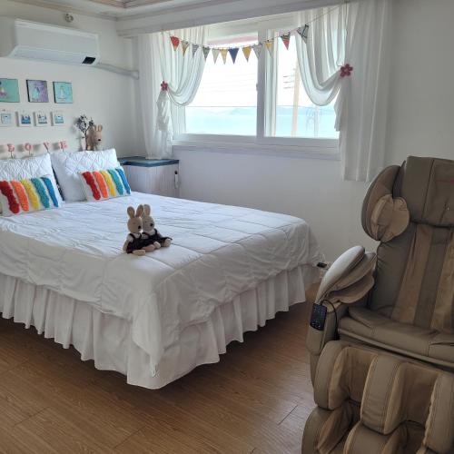 a bedroom with a bed with two teddy bears on it at Soulmate Pension in Namhae