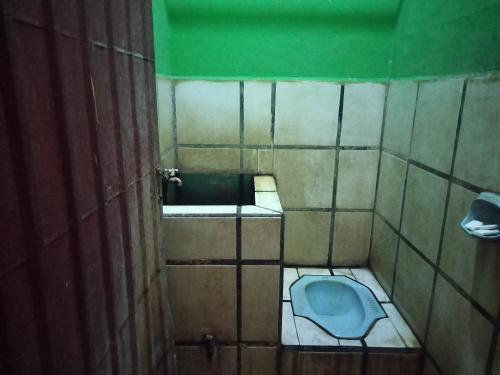 uma casa de banho com WC num quarto em azulejo em SPOT ON 92601 Penginapan Keluarga em Medan