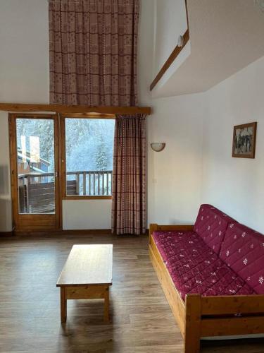 un salon avec un canapé violet et une table dans l'établissement La Tania La Saboia sleep 8 private Sauna lounge dining 2 bathrooms kitchen 2 balconies ski in out, à La Tania