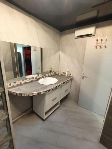 une salle de bain avec un lavabo et un miroir dans l'établissement Appartement Le Secret Spa billard sensualité, à Espondeilhan