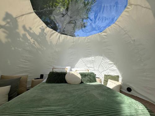 ein Schlafzimmer mit einem Bett in einem weißen Zelt in der Unterkunft Au Domaine du Prédieu in Crécy-sur-Serre