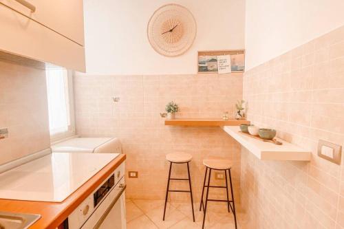 a kitchen with two bar stools and a sink at Locazione turistica Davide in Anzio