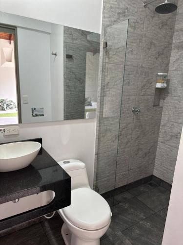 a bathroom with a toilet and a sink and a shower at Hotel Parador del Gitano in Doradal