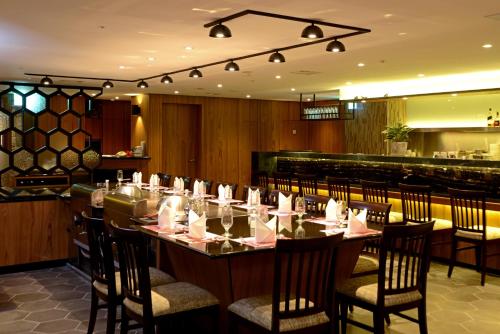 a dining room with a long table and chairs at Brother Hotel in Taipei