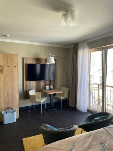 a hotel room with a desk and a television at The Green Rostock Apartment Hotel in Rostock
