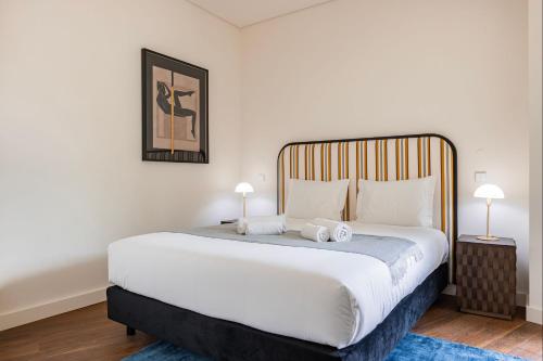 sypialnia z dużym białym łóżkiem z 2 lampami w obiekcie Upscale Apartment in City Center by LovelyStay w Lizbonie
