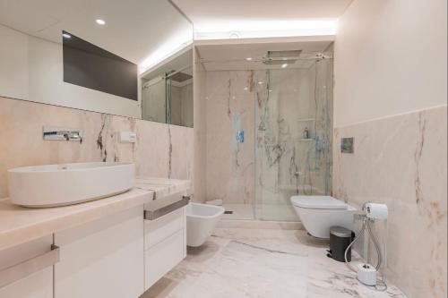 W łazience znajduje się umywalka, toaleta i prysznic. w obiekcie Upscale Apartment in City Center by LovelyStay w Lizbonie