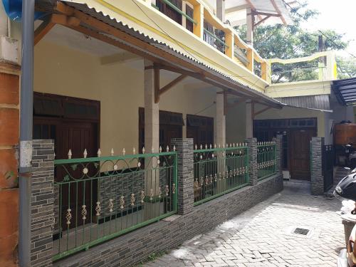a green fence in front of a building at OYO Life 92620 Syfa Kost in Malang