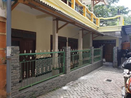 a green fence in front of a house at OYO Life 92620 Syfa Kost in Malang