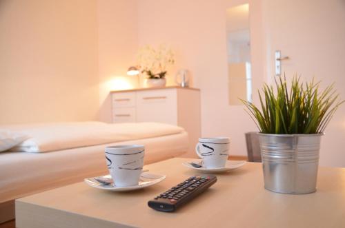 sala de estar con 2 tazas de café y control remoto en Bałtyckie-Hel, en Hel