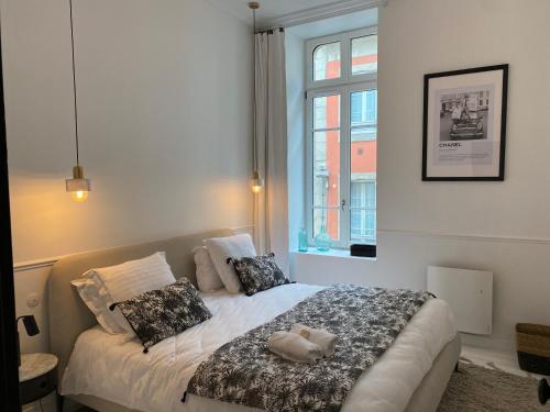 1 dormitorio con cama con almohadas y ventana en N9 APPARTEMENT DE CHARME **** MORLAIX, en Morlaix