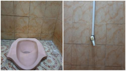 a bathroom with a pink toilet in a tiled floor at OYO Life 92622 Jatiluhur Kost Syariah in Malang
