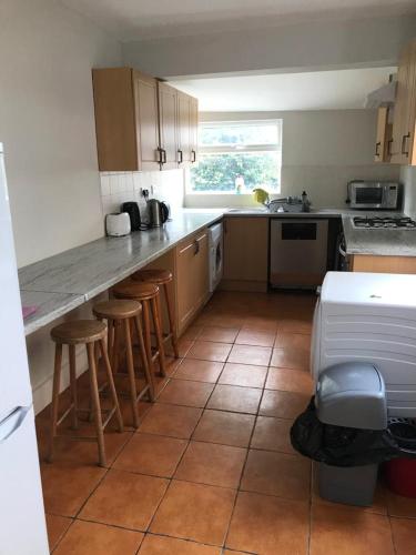 a kitchen with a counter and stools in it at Modernified Properties in Canterbury