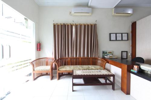 Sala de estar con 2 bancos y mesa en OYO 92629 Pondok Kawandya, en Karanganyar