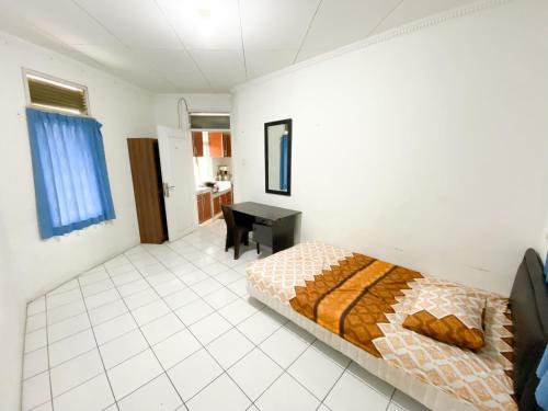 a bedroom with a bed and a desk in it at OYO Life 92630 Siliwangi Residence 63 in Bandung