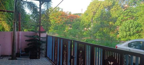 a balcony of a house with a fence and trees at JEENA Homestay VILLA in Kollam