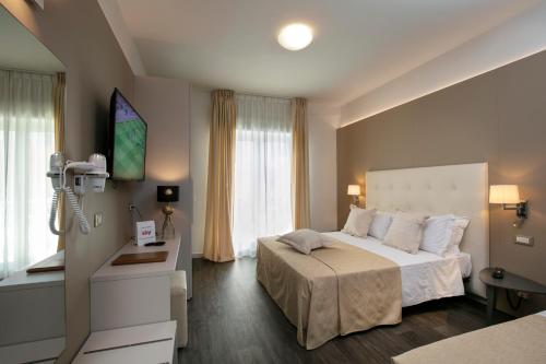 a hotel room with a large bed and a window at Hotel Ca' Bianca in Riccione