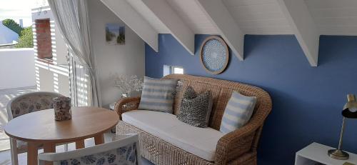 a living room with a wicker chair and a table at Milk Thistle Loft & Studio apartments in Paternoster